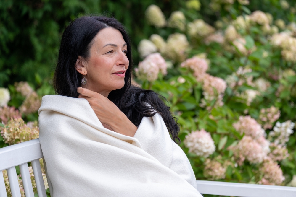 A,Mature,Woman,,Wrapped,Warmly,,Gazes,Into,The,Distance,,Her
