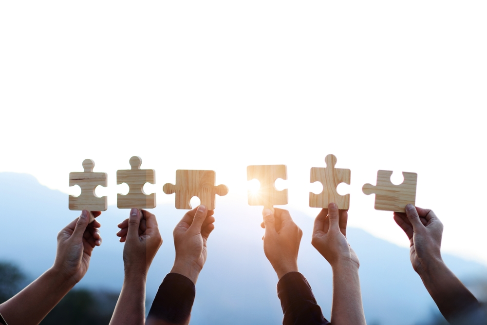 Teamwork,And,Partnership,Concept.,Hands,Are,Raised,Against,A,Bright,